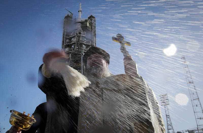 An Orthodox priest conducts a blessing service in front of the Soyuz FG rocket at the Russian leased Baikonur cosmodrome.