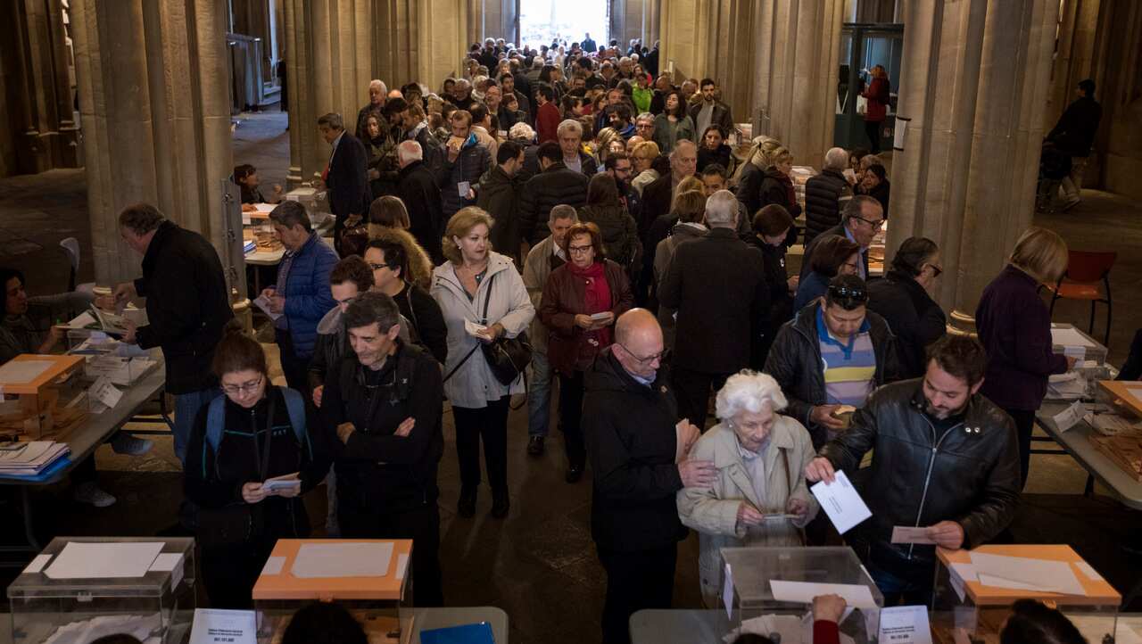 People cast their votes during Spain's general election in a polling station in Barcelona.