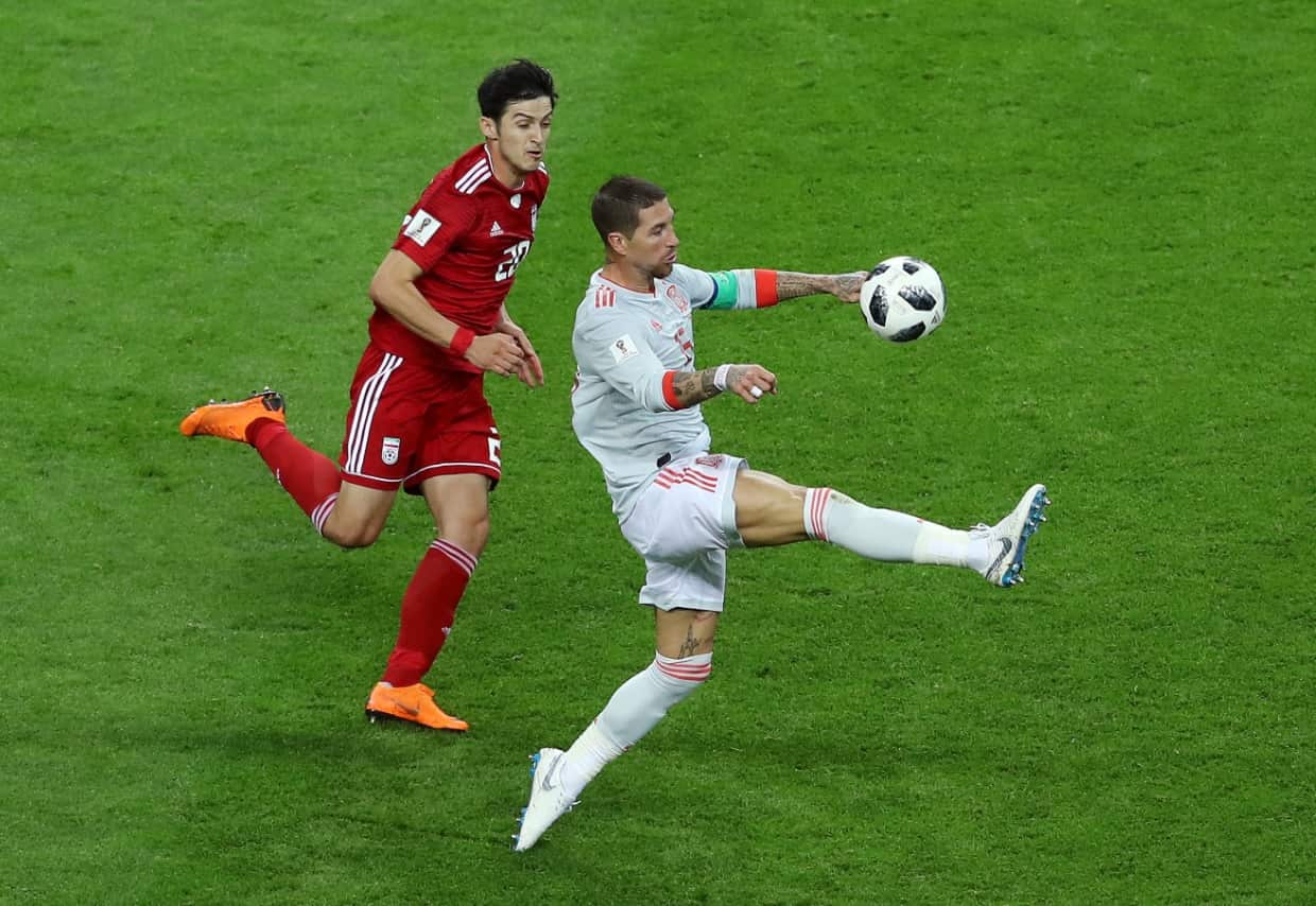 Sergio Ramos of Spain controls the ball under pressure from Sardar Azmoun of Iran