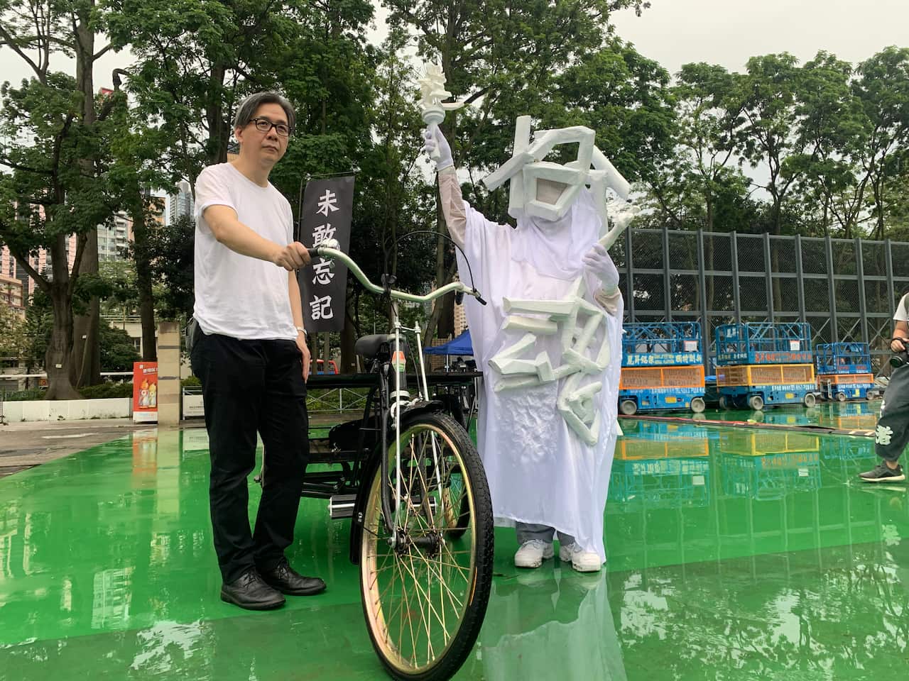 A protester with the Goddess of Democracy recreation in Victoria Park, where the protest will take place.