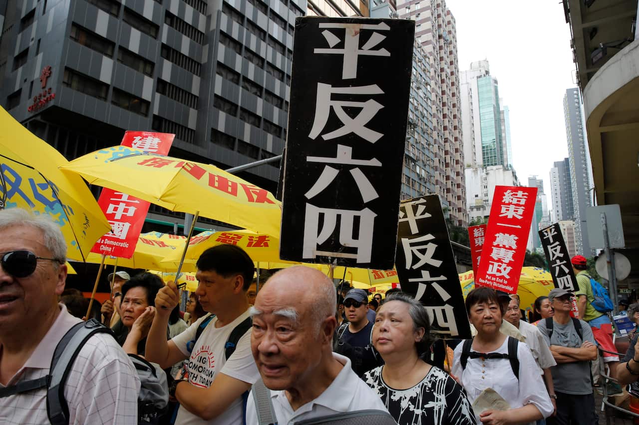 Hong Kong protesters carry placards reading "Vindicate June 4th" and "Put an end to one-party Dictatorship”.