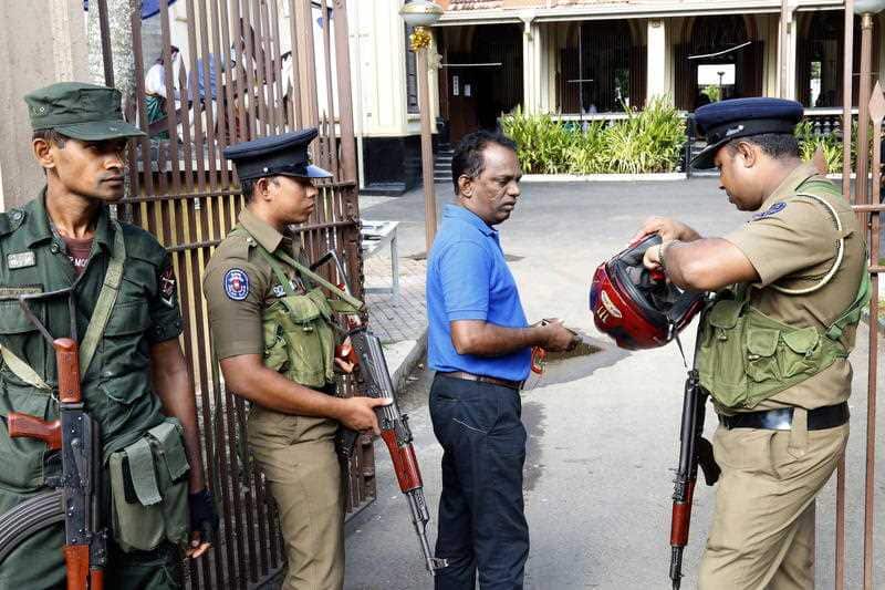 Sri Lankan Security personnel check people before they enter the church as services resume again after the Easter Sunday attacks,