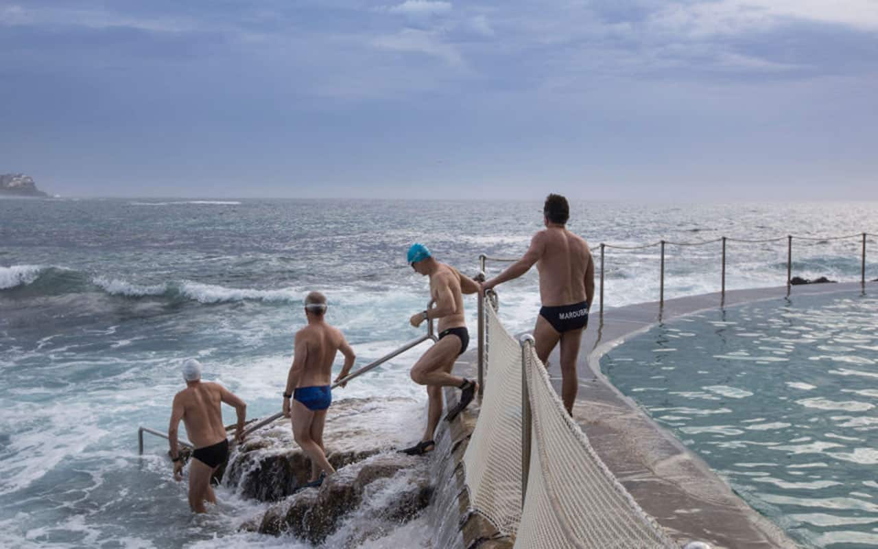 Ocean swimmers make their way into the sea from the wall of the ocean pool at Bronte Beach on December 16, 2017 in Sydney, Australia.