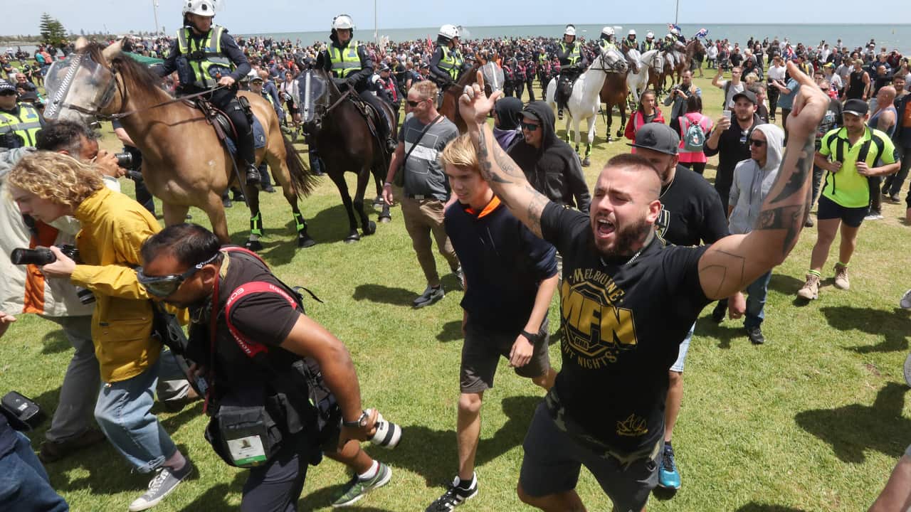 Ugly scenes at the St Kilda foreshore in Melbourne as far-right groups face off with anti-racism groups. Large group of police watch on.