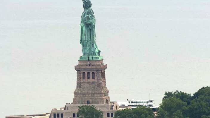 A person scaled the statue's base and forced its evacuation shortly after several other people were arrested for hanging a banner from the pedestal. 