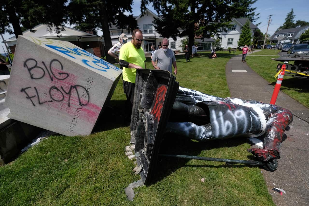 Workers work out how to haul away the George Washington statue in Portland Oregon after it was pulled down on 18 June 2020.