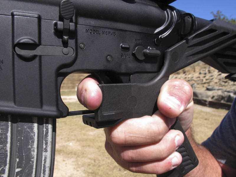 An instructor demonstrates the grip on an AR-15 rifle fitted with a bump stock, which allows the semi-automatic rifle to fire on automatic.