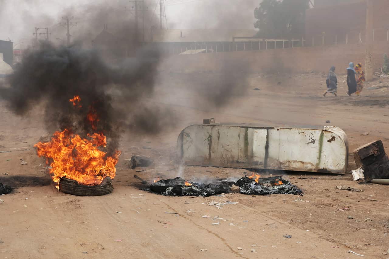 A tire burns at a roadblock in the center of Khartoum, Sudan.