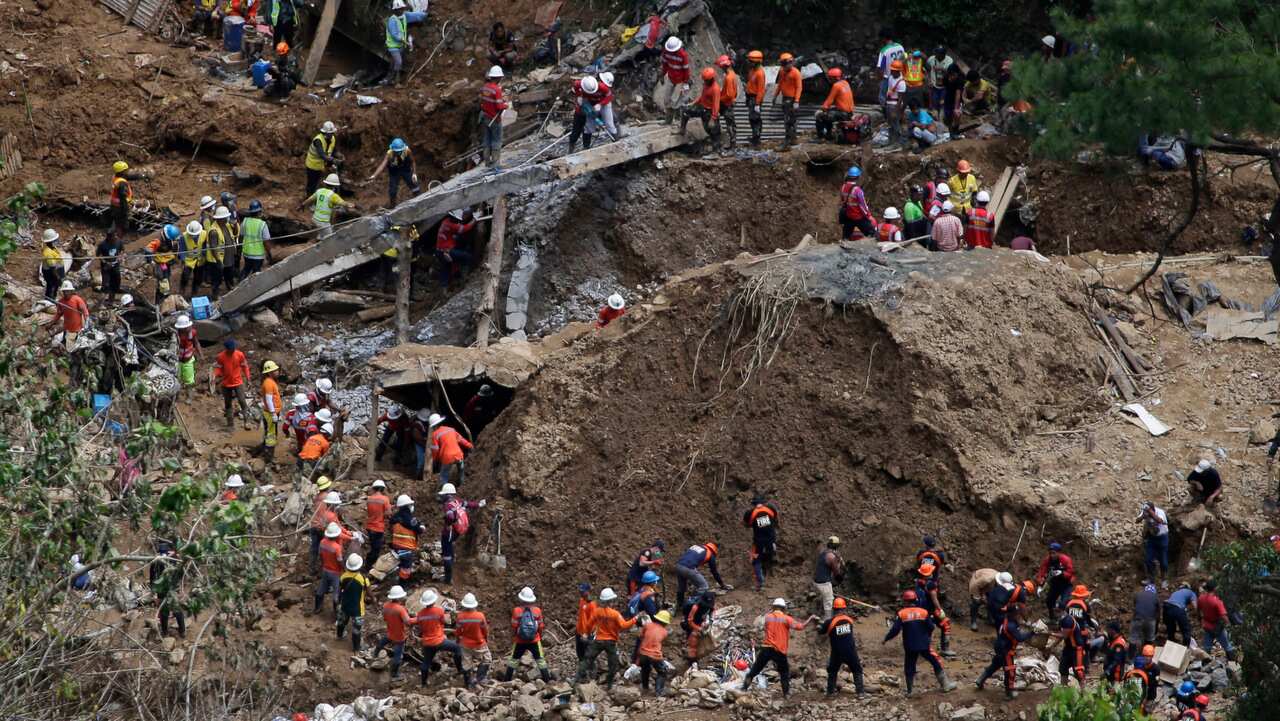 Rescuers search for victims at the site of a landslide set off by Typhoon Mangkhut in the northern Philippines.