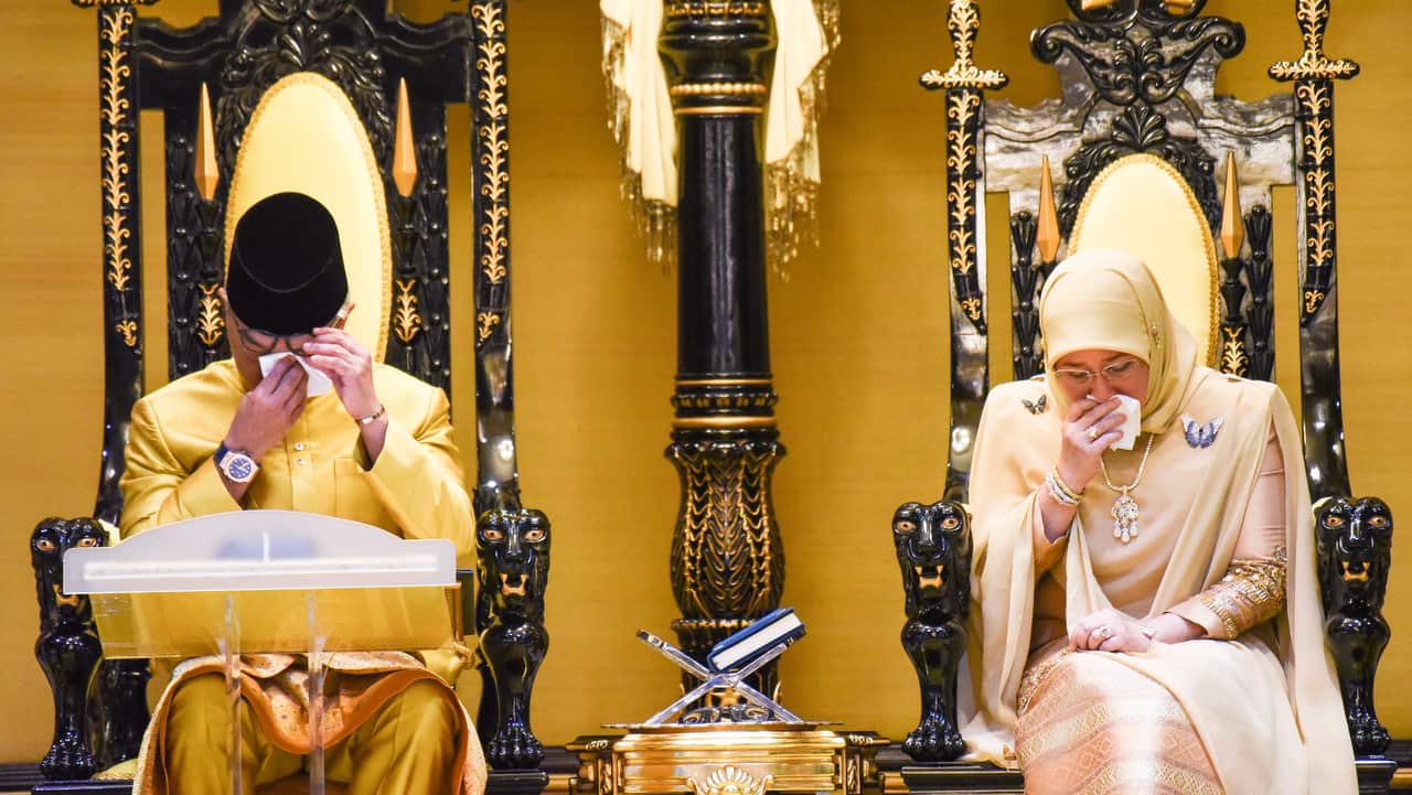 Sultan Abdullah ibni Sultan Ahmad Shah and his consort react after the new sultan delivered his address during their coronation.
