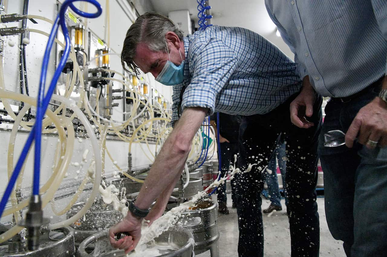 NSW Premier Dominic Perrottet taps a beer keg during a tour of the Marsden Brewhouse in Marsden Park.