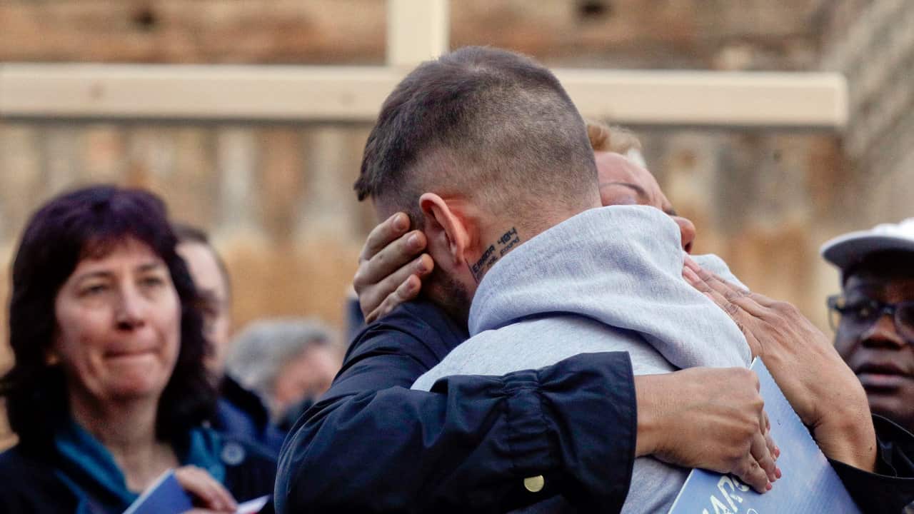 Survivor Alessandro Battaglia (right) is hugged by fellow survivor Denise Buchanan and founding member of the Ending Clergy Abuse as he recounts his experience.