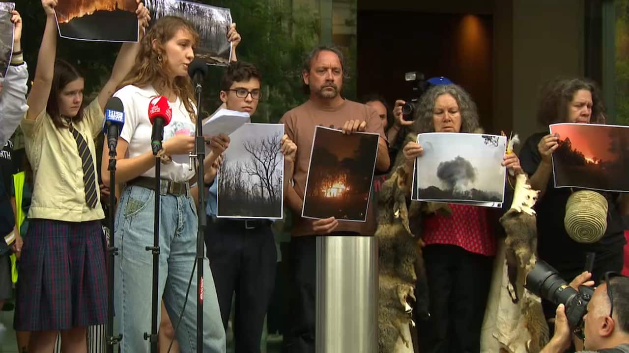 Bushfire survivor Shiann Broderic tells protesters how she lost her home in the recent bushfire at Nymboida, NSW.