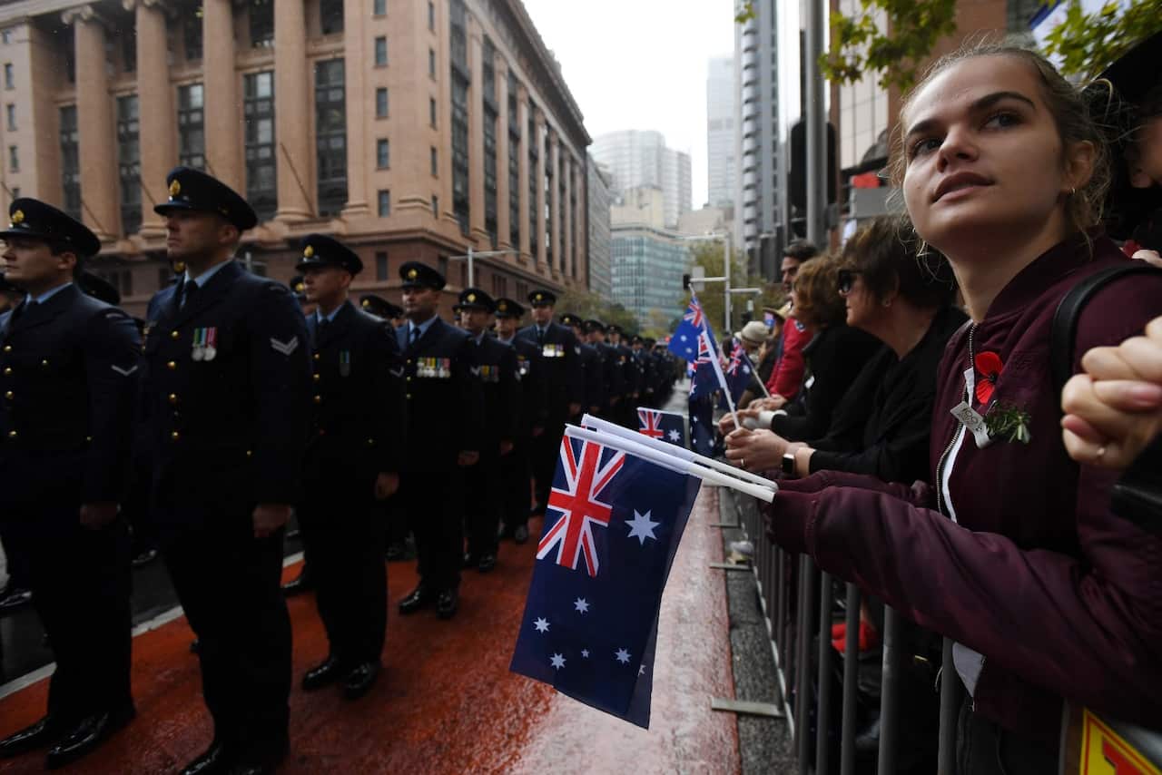 A girl looks round as she watches the Anzac Day march in Sydney, Wednesday, April 25, 2018. 