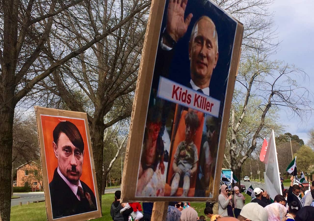 Signs comparing the Russian president to Adolf Hitler.