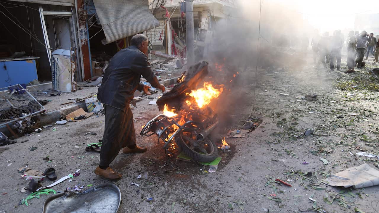 A man tries to put out a fire after a car bomb exploded in Tal Abyad, Syria.  A car bomb exploded in the northern Syrian town.