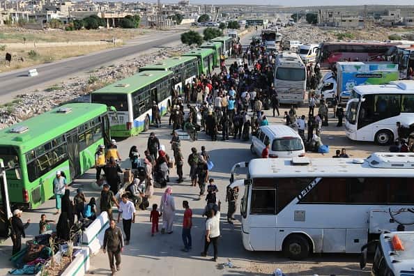 People get on buses, headed towards temporary refugee centers in Idlib, after a deal struck between Assad Regime and opposition forces.