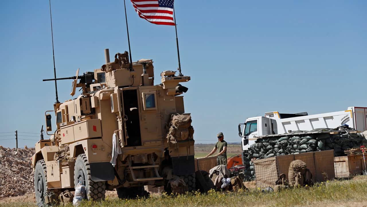 A US soldier sets sand barrier bags at a newly installed position near the tense front line between the US-backed and the Turkish-backed fighters, in Manbij.