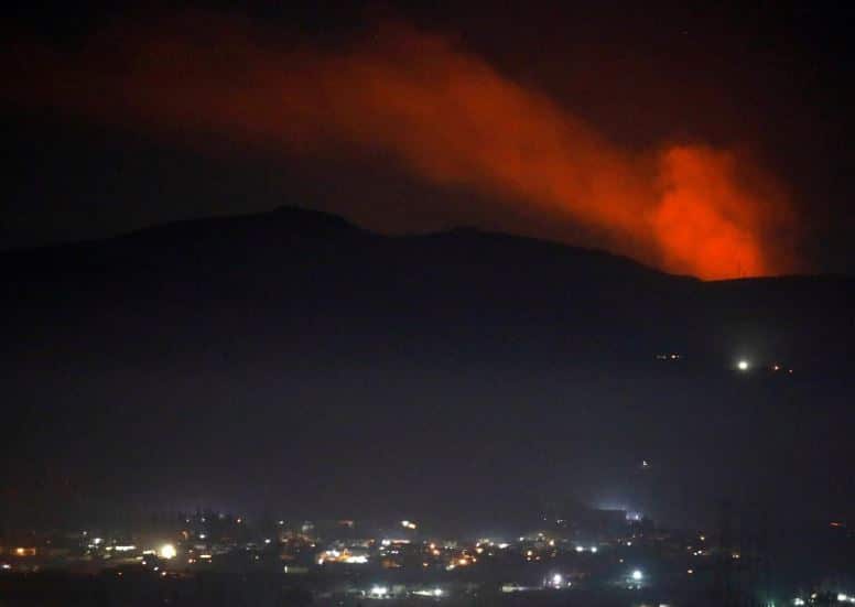 Smoke rises past a mountain as seen from the Damascus countryside on December 25.