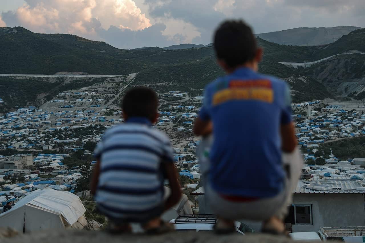 Two children look at a camp for forcibly displaced people in Khirbet al-Joz, Latakia, Syria, 31 May 2018.