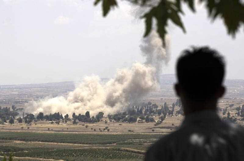 Smoke rises from the Syrian city of Quneitra. Israel said rebel forces had detonated ammunition stores  before retreating from a massive regime offensive.