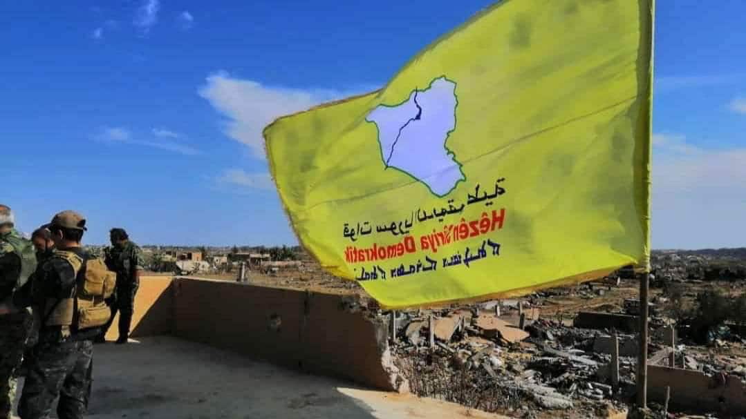 The yellow flag of US-backed Syrian Democratic Forces (SDF)  raised in the village of Baghuz, Syria, after the defeat of IS fighters.