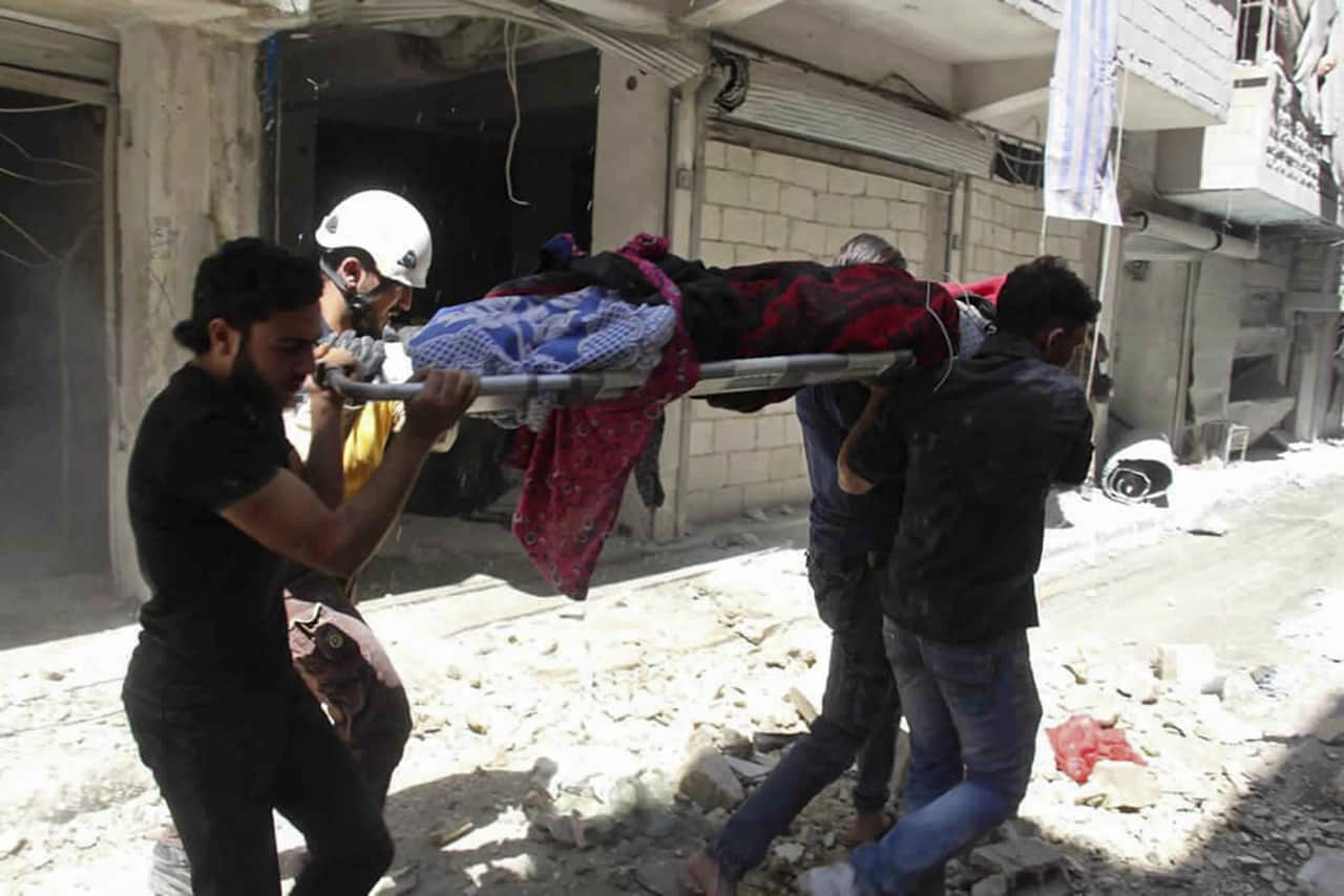 Syrians carrying an injured person on a stretcher after an airstrike by Syrian government forces, in the the town of Ariha, in the province of Idlib, Syria.