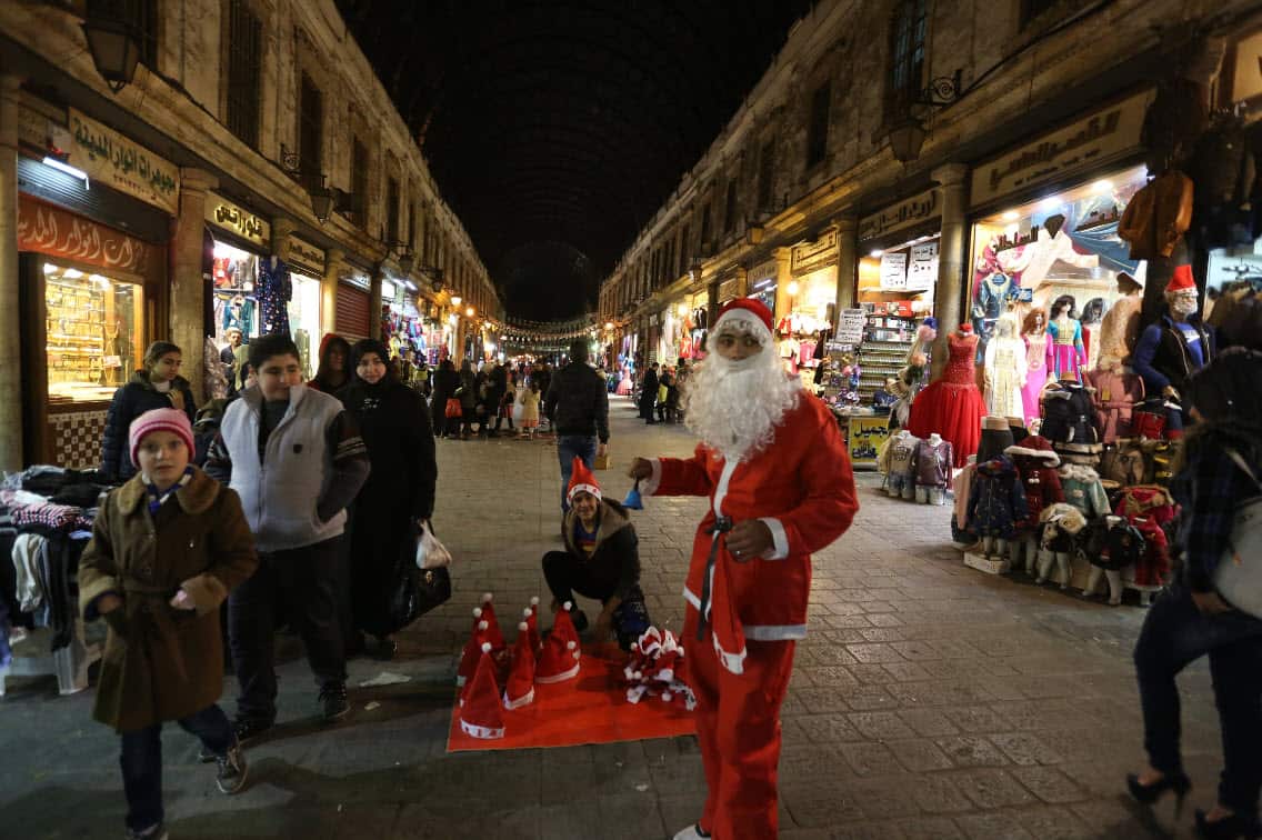 A Syrian is dressed as Santa Claus clothes in Damascus.