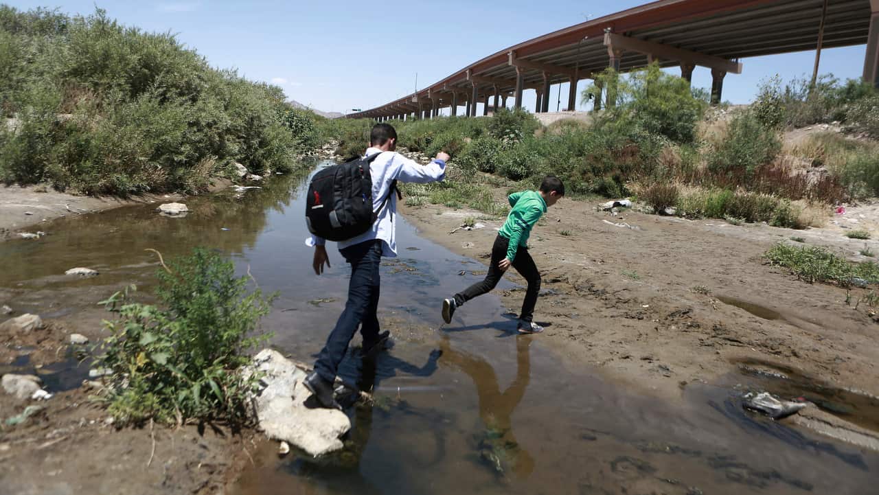 Migrants cross the Rio Grande into the US to turn themselves over to authorities and ask for asylum, as seen from Ciudad, Juarez.