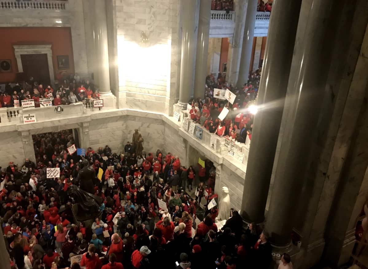Protesters hold signs and shout slogans as thousands of Kentucky teachers, along with student inside the Kentucky State Capitol 