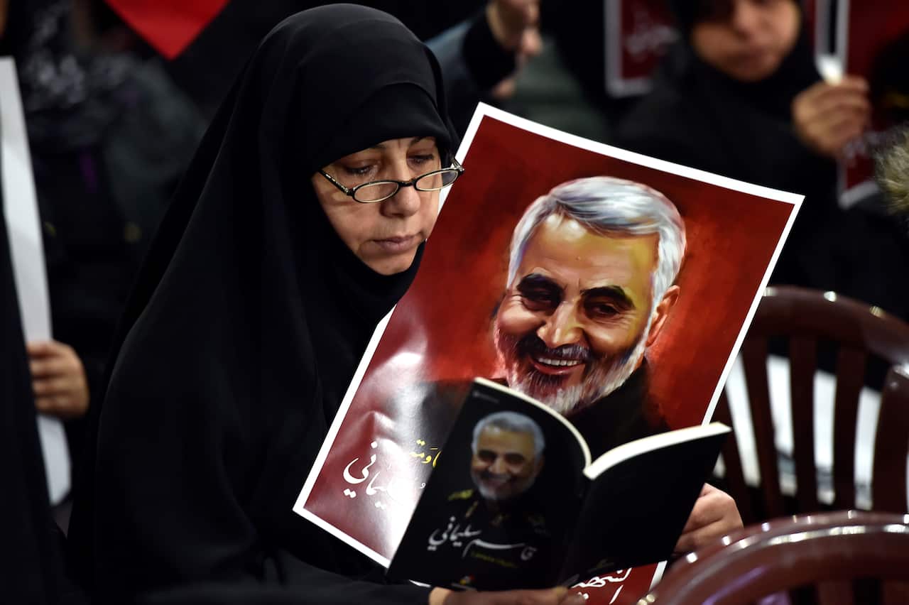 A woman carries a picture of slain Iranian Revolutionary Guards Corps General and commander of the Quds Force Qasem Soleimani during a rally in Beirut, Lebanon.