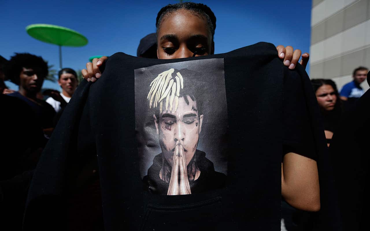 Anneyah Lawson, 14, holds up a sweatshirt with an image of slain rapper XXXTentacion, before his memorial.