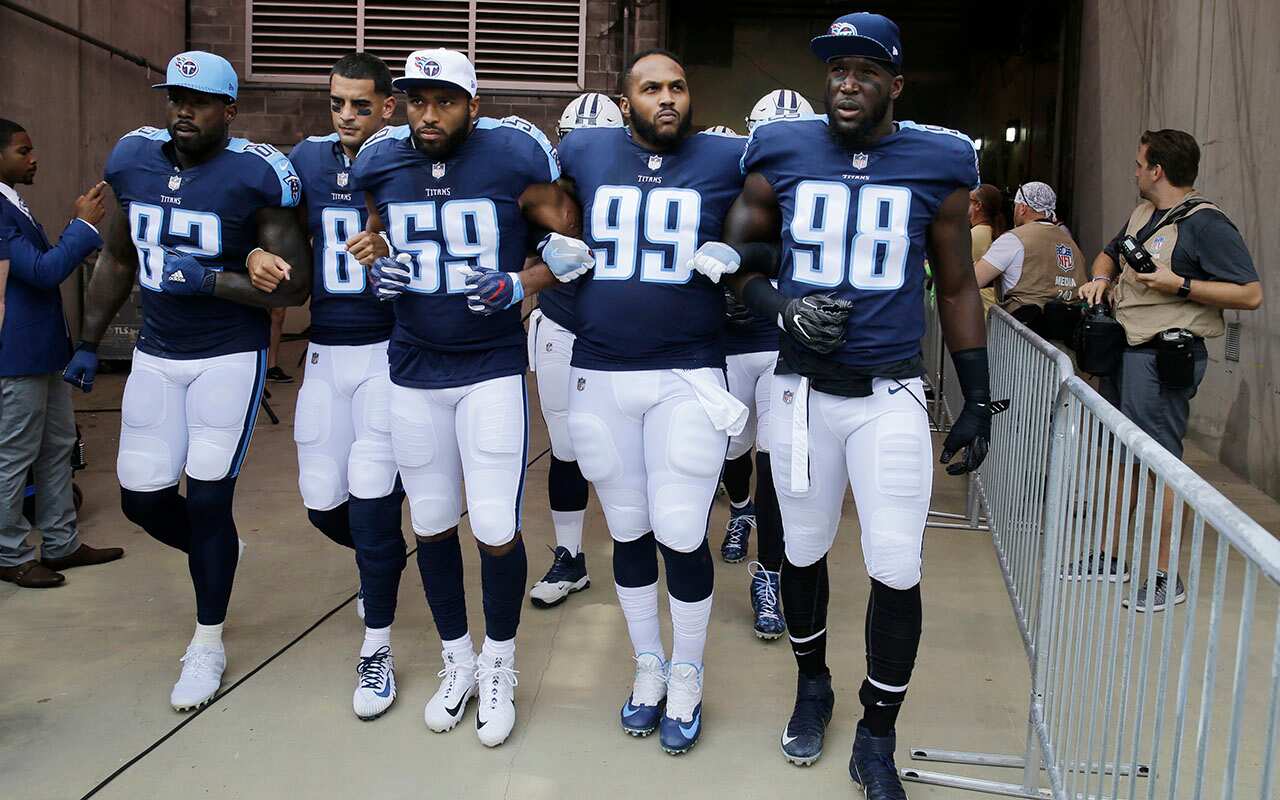 Tennessee Titans players walk to the field with arms linked before game between Titans and Seattle Seahawks. Neither team stood on the field for the anthem. 