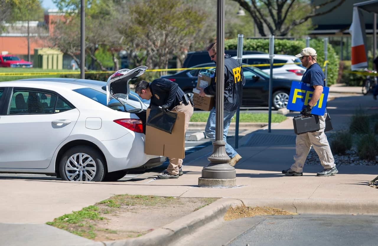 FBI agents are seen carrying items out in paper bags and boxes as they exit the FedEx store as the aid the police