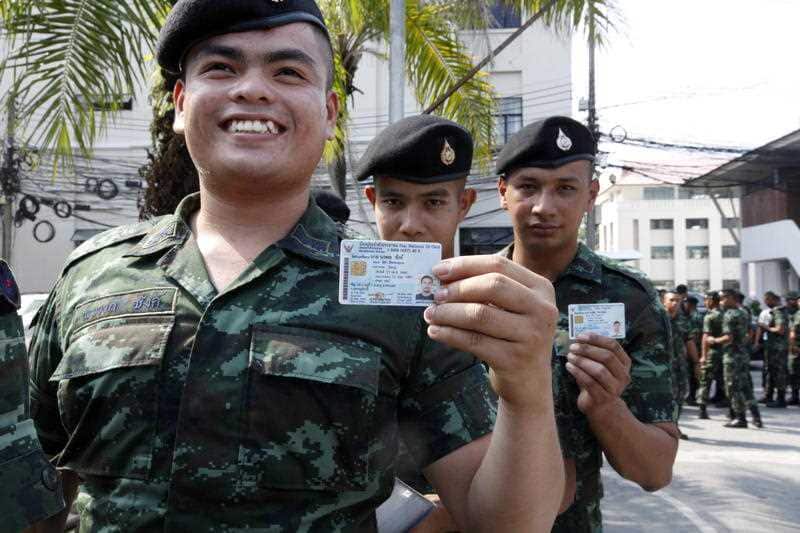 Thai soldiers display their identity cards during the advance voting in the general election in Pattani province, southern Thailand.