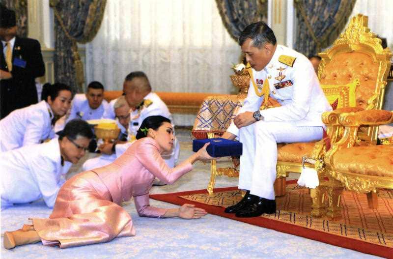 Thailand's King Maha Vajiralongkorn, right, presents a gift to Queen Suthida Vajiralongkorn Na Ayudhya at Ampornsan Throne Hall in Bangkok.
