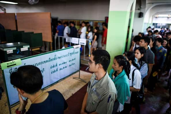 People wait in a queue to cast their ballots during early voting in Bangkok.