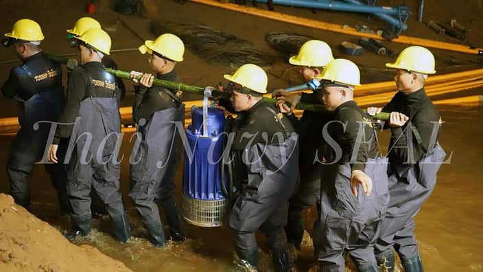 Thai soldiers carry equipment inside a cave complex during the ongoing rescue operations.