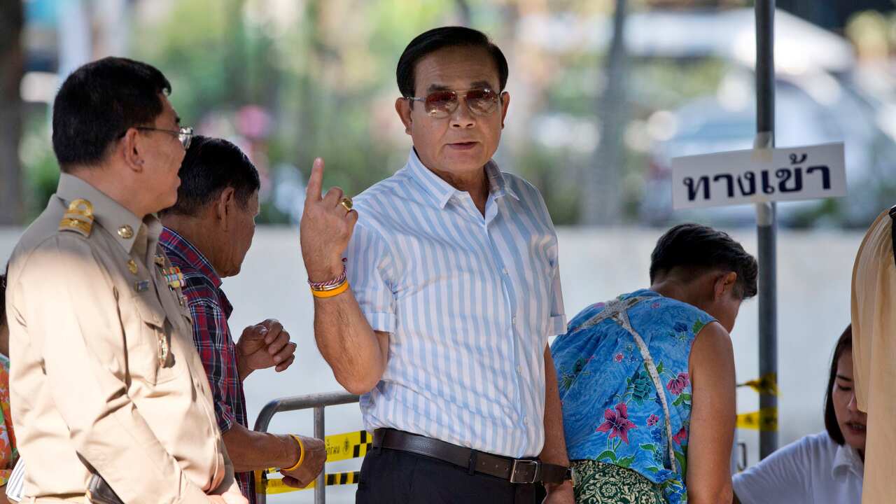 Thailand's Prime Minister Prayuth Chan-ocha gestures as he stands in a line to cast his vote at a polling station in Bangkok.