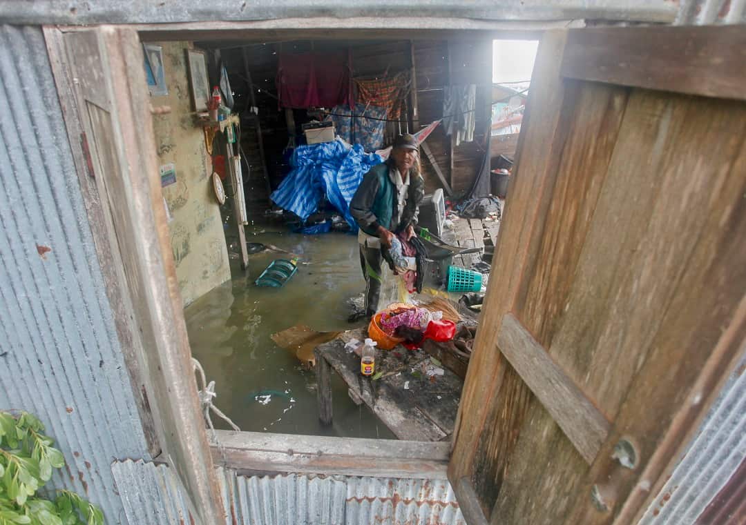 A Thai man sorts through debris in the aftermath of Tropical Storm Pabuk.