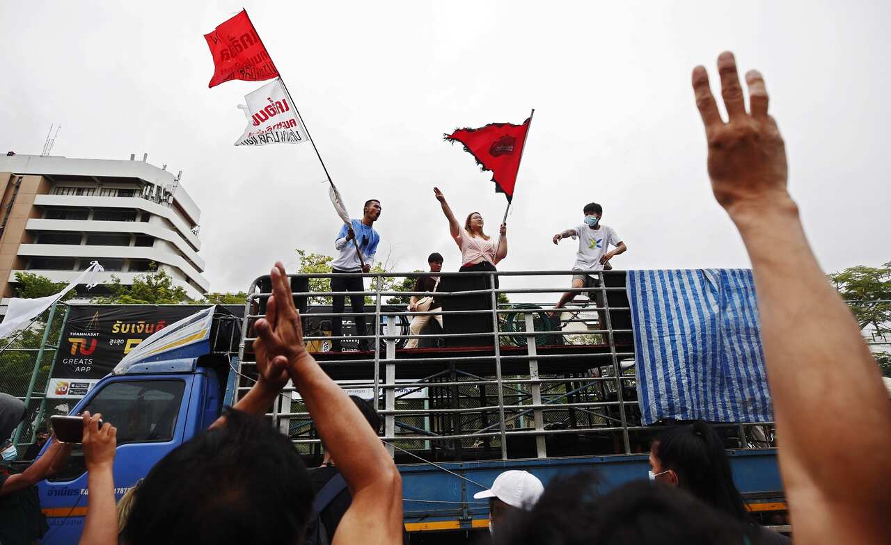 Pro-democracy protest leader Panupong Jadnok (back left) waves flags on a truck outside Thammasat University during a protest in Bangkok.