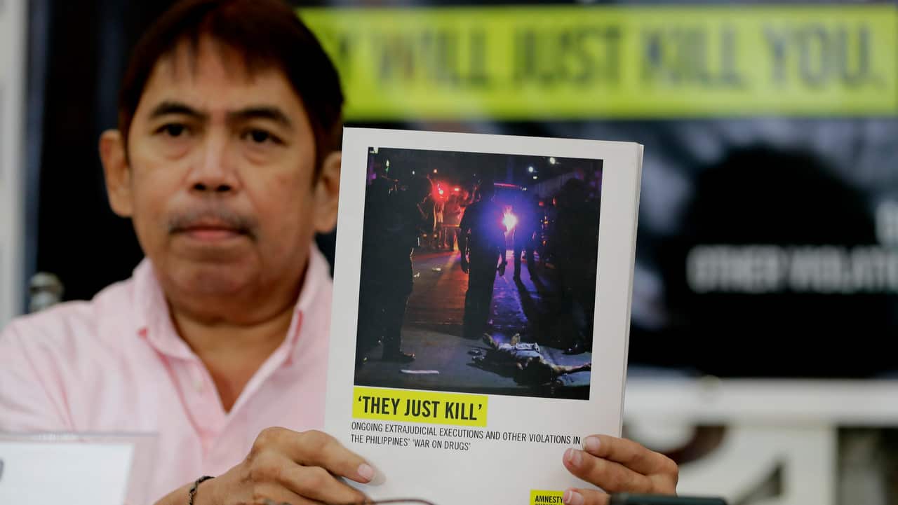 Butch Olano, Amnesty International Section Director in the Philippines, holds a copy of Amnesty's report.