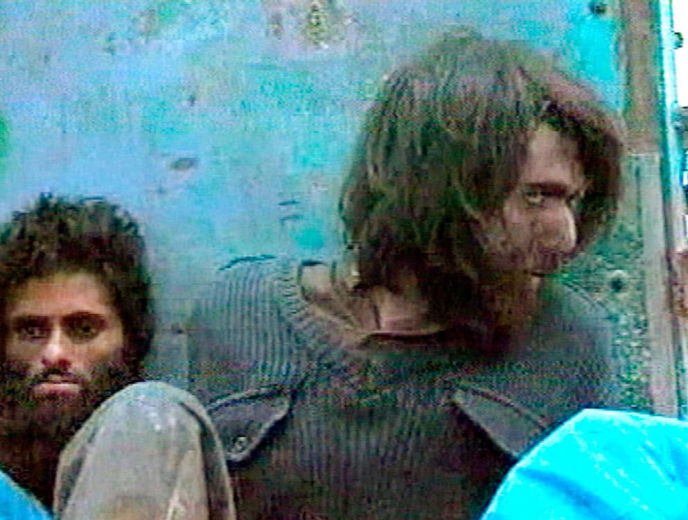 This file image taken Dec. 1, 2001, from television footage in Mazar-i-Sharif, Afghanistan, shows John Walker Lindh, right, claiming to be an American Taliban volunteer (AAP)