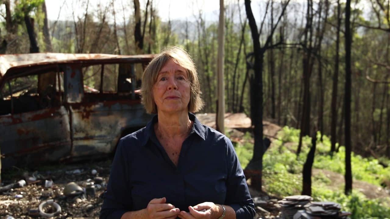 Janet Reynolds standing on her property after it was destroyed by fire. 