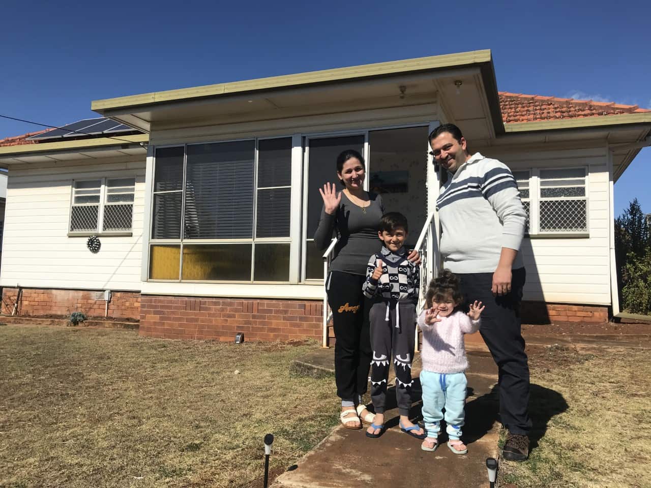 Jankey Joweesh with his family in front of their new home in Toowoomba.
