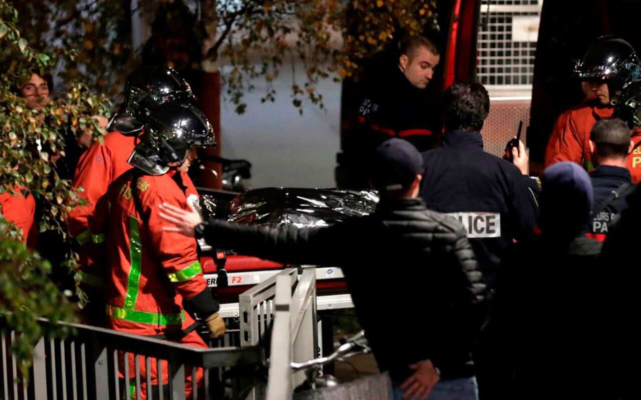 Police officials and rescue personnel transport the body of a tiger which had escaped from a circus into a vehicle in Paris on November 24, 2017.