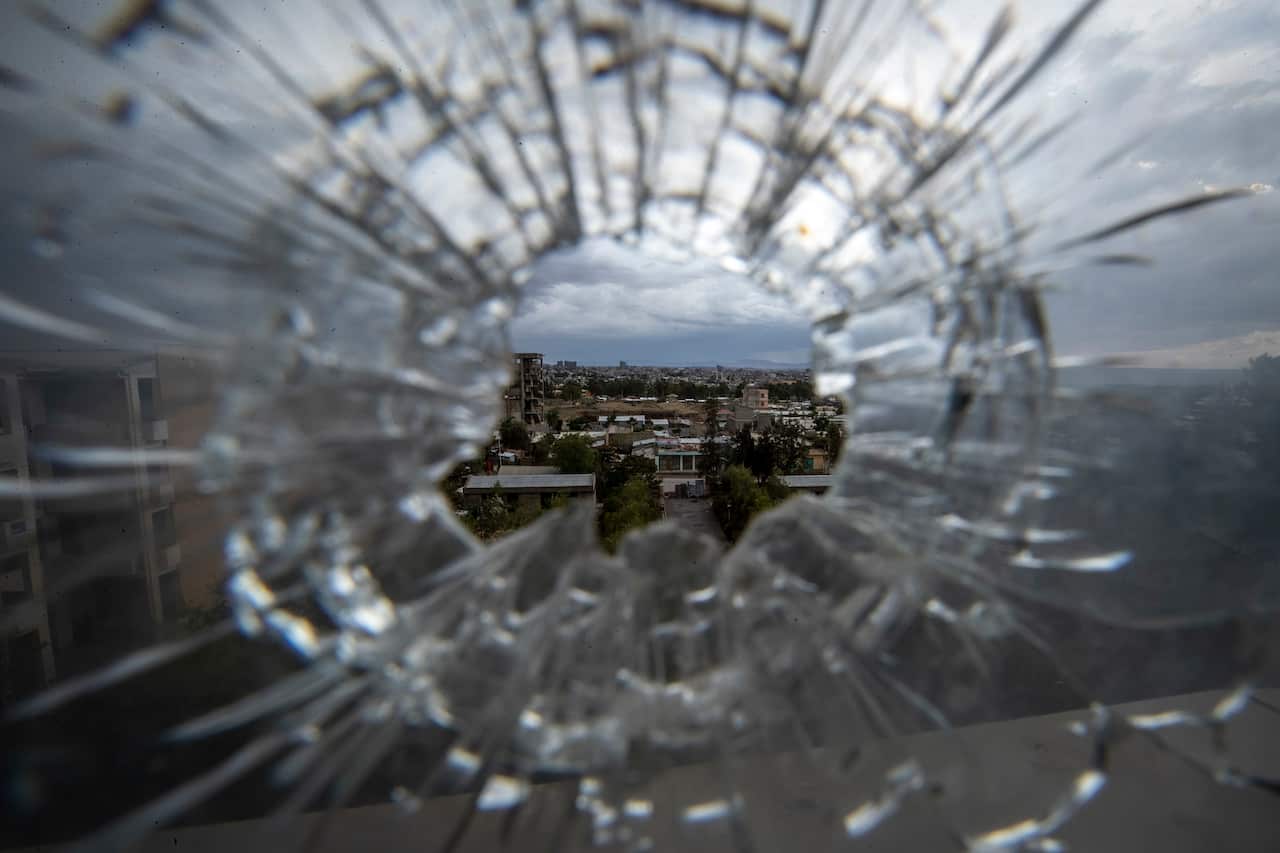 The city of Mekele is seen through a bullet hole in a stairway window of the Ayder Referral Hospital, in the Tigray region of northern Ethiopia.