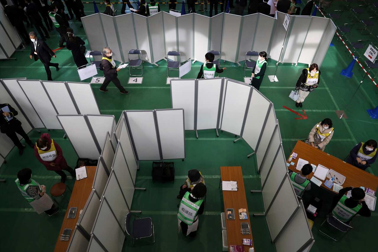 People participate in a coronavirus vaccination simulation at Kawasaki City College of Nursing in Kawasaki.