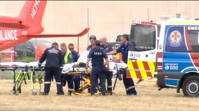 Paramedics bundle the stabbed prisoner into a helicopter. 