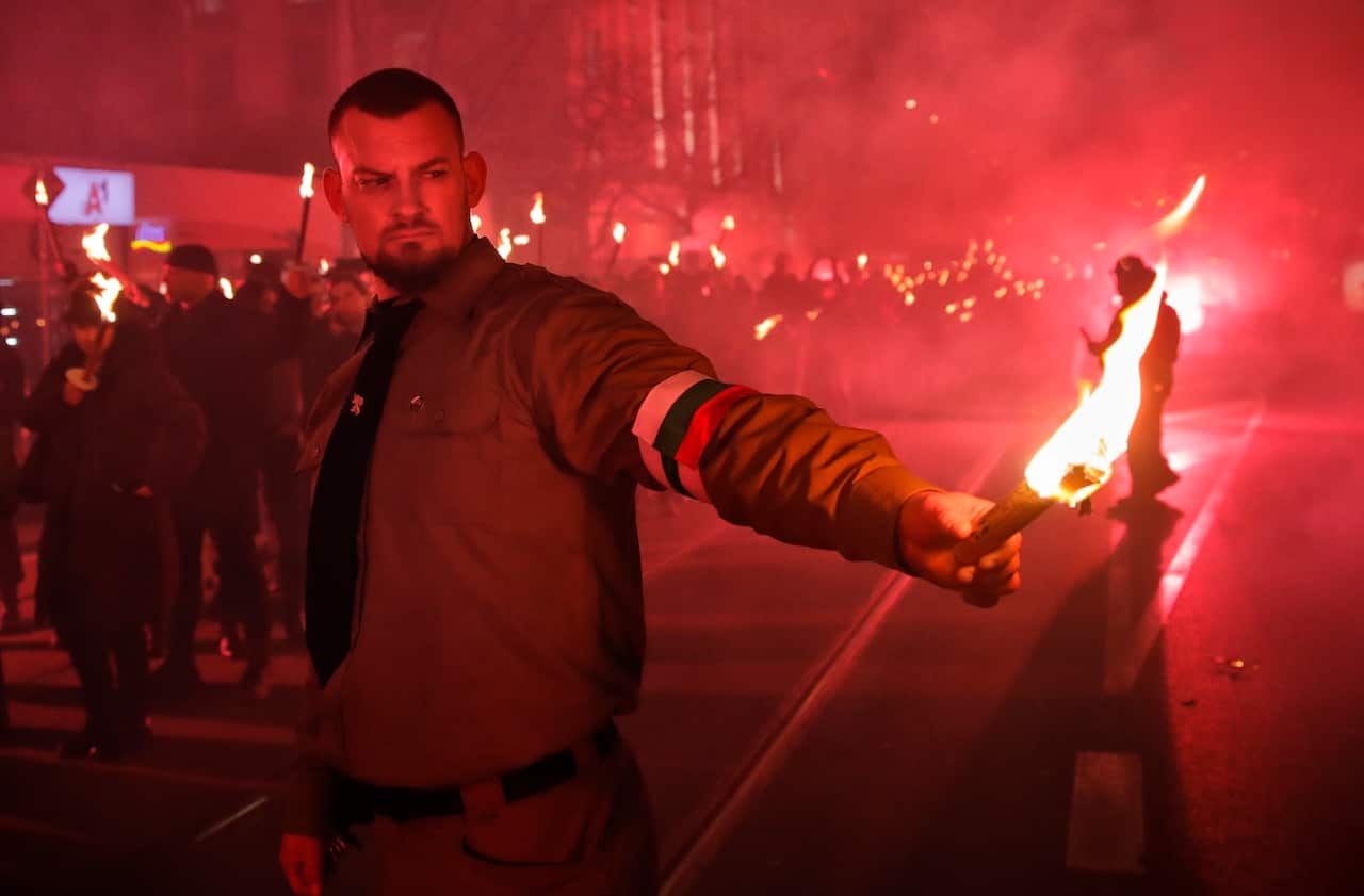 A child holds a flare as people take part in the "Lukov March," staged by the far-right Bulgarian National Union, in Sofia, Bulgaria, Saturday, Feb. 16, 2019.